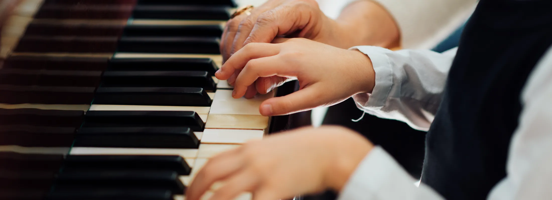Élève apprenant le piano avec son professeur